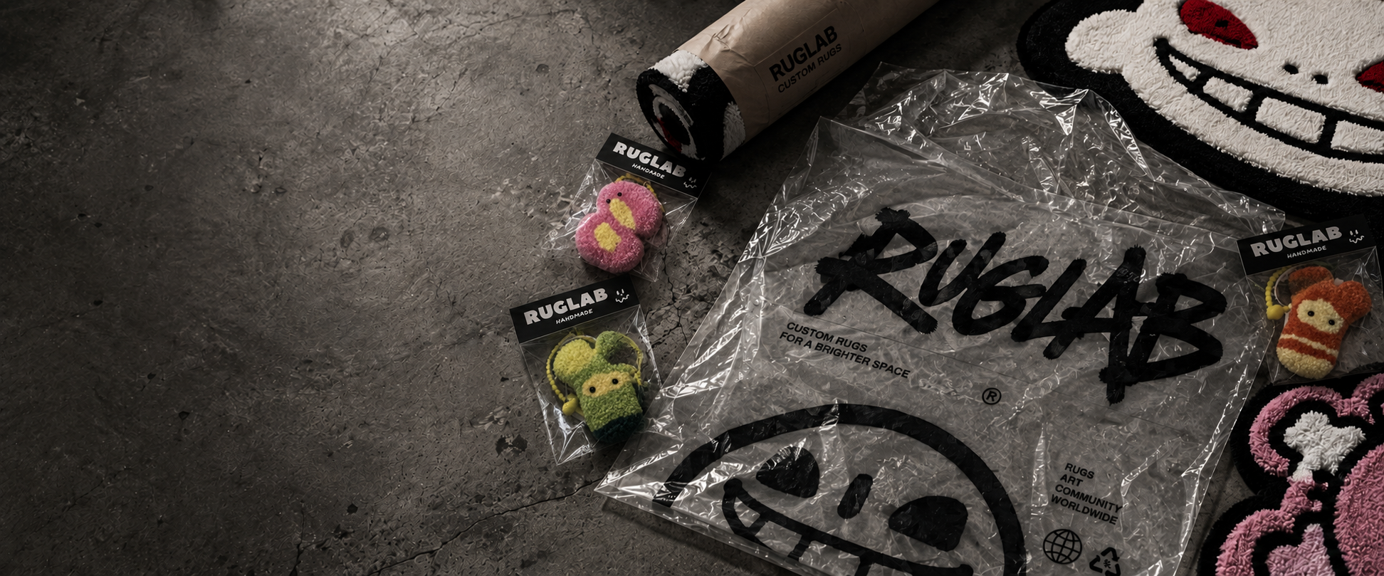 RUGLAB packaging, rolled tufted rug and handmade keychains on concrete